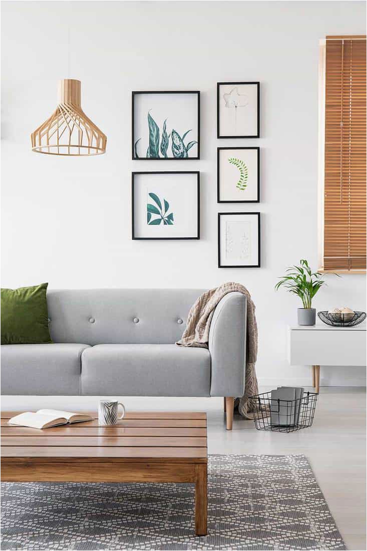 Posters on a wall in a living room interior with grey sofa and low coffee table