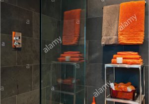 Bright orange Bath Rugs Bright orange towels In Bathroom with Slate Tiles Stock